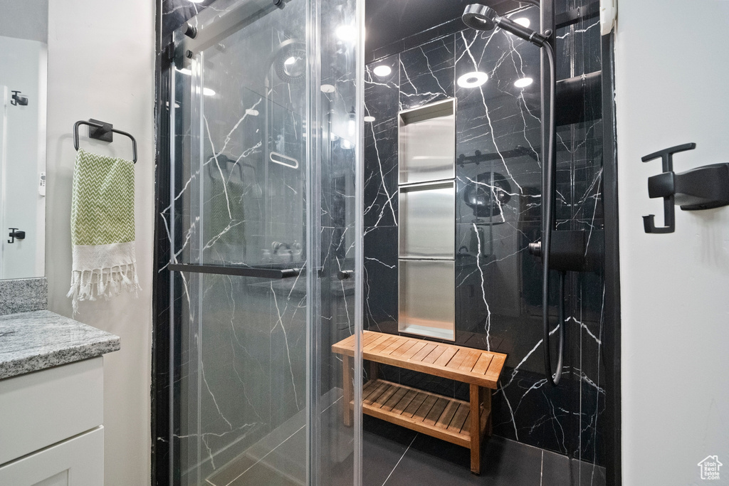 Full bath with a marble finish shower and vanity