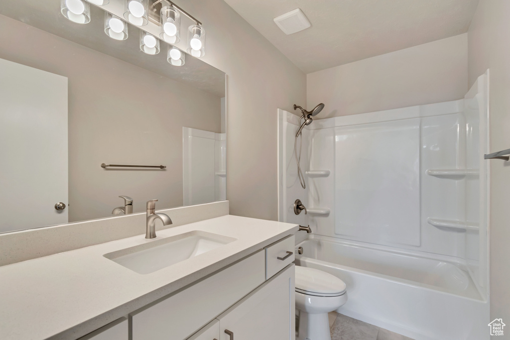 Full bath with toilet, vanity, tile patterned floors, and bathing tub / shower combination