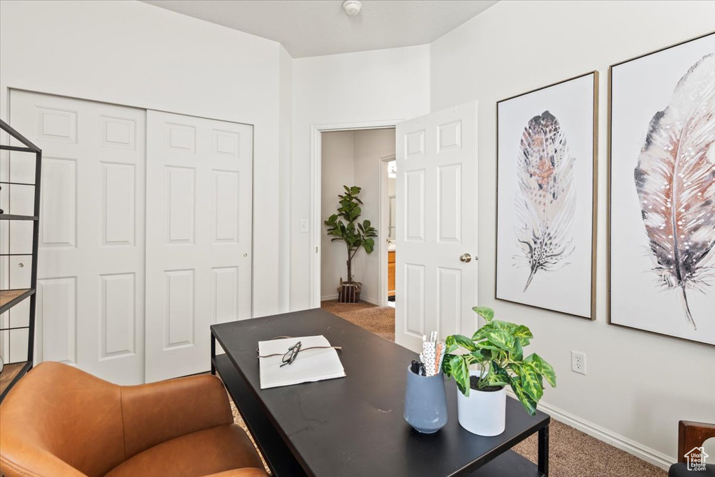Carpeted office space featuring baseboards