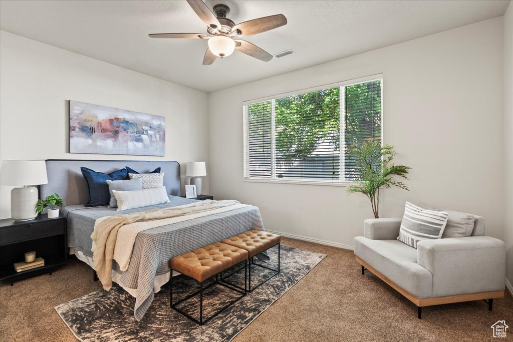 Carpeted bedroom with a ceiling fan and baseboards