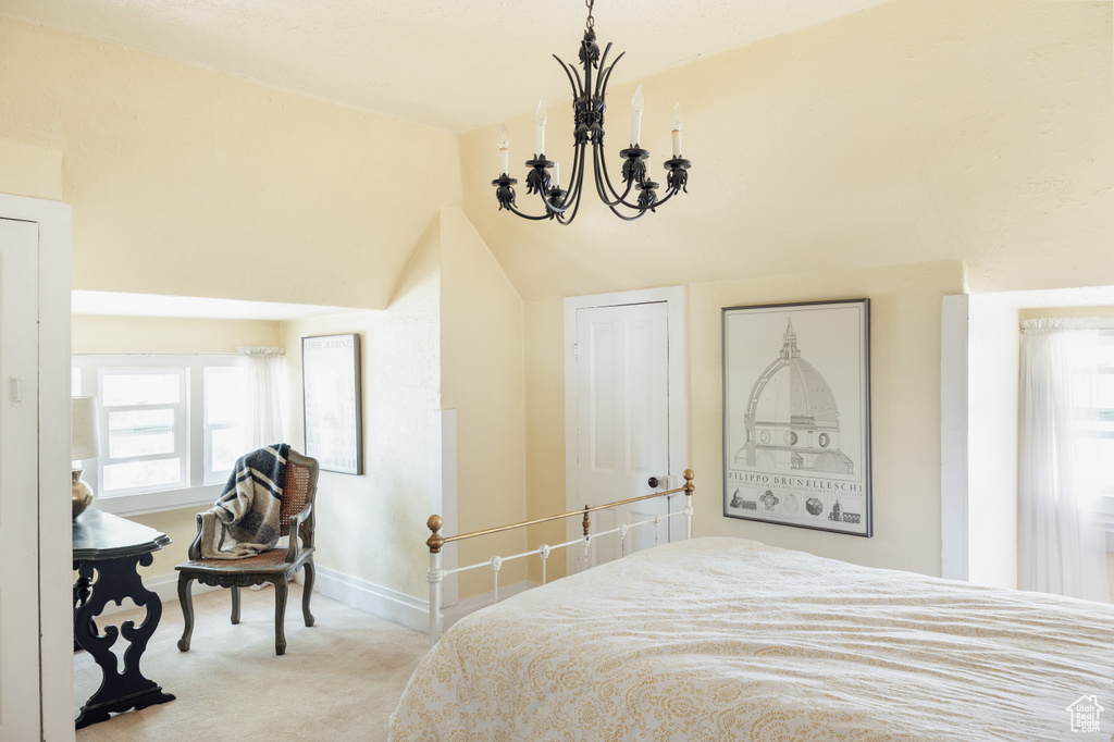 Carpeted bedroom featuring a chandelier, multiple windows, baseboards, and vaulted ceiling