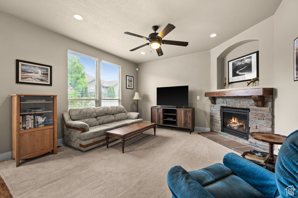 Living room with a ceiling fan, a fireplace, light carpet, recessed lighting, and baseboards