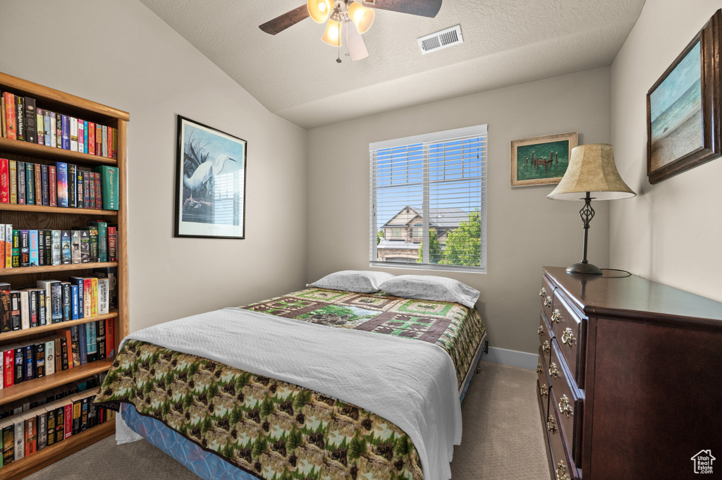 Bedroom featuring carpet flooring, baseboards, lofted ceiling, and ceiling fan
