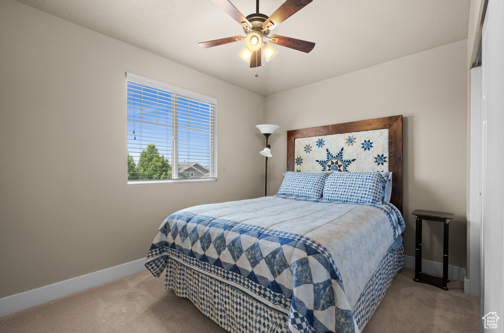 Carpeted bedroom with baseboards and ceiling fan