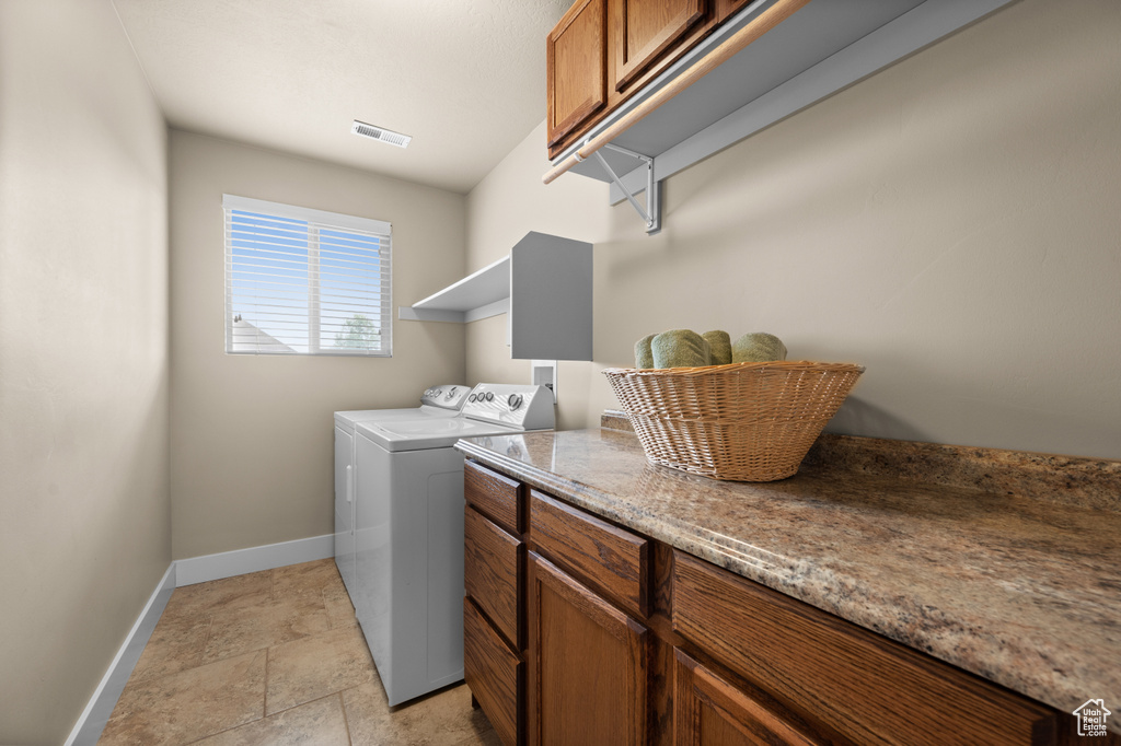 Laundry room with baseboards, independent washer and dryer, and cabinet space