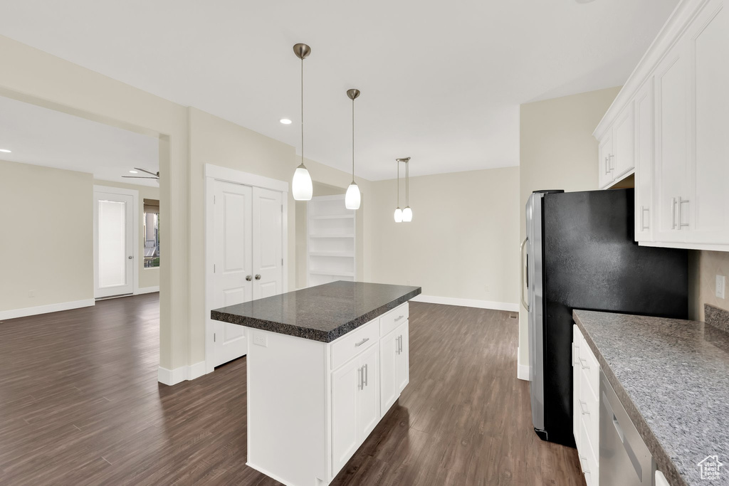 Kitchen with appliances with stainless steel finishes, baseboards, dark wood finished floors, white cabinetry, and recessed lighting