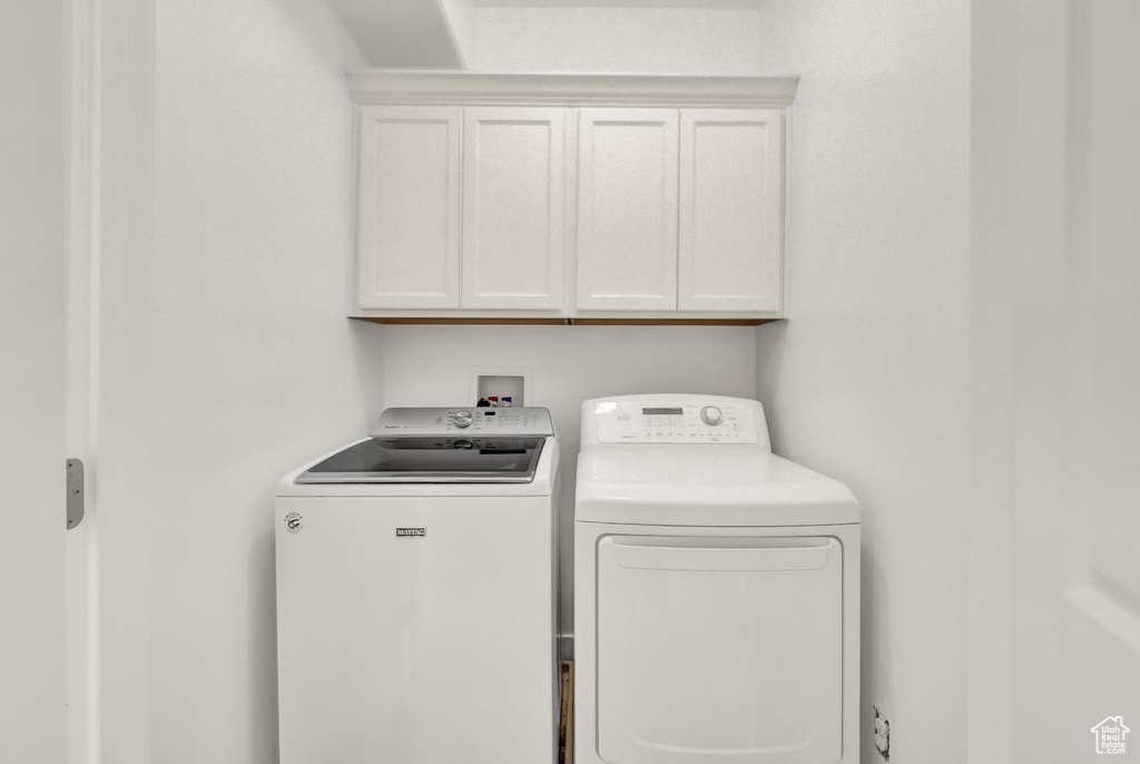 Washroom featuring washer and clothes dryer and cabinet space
