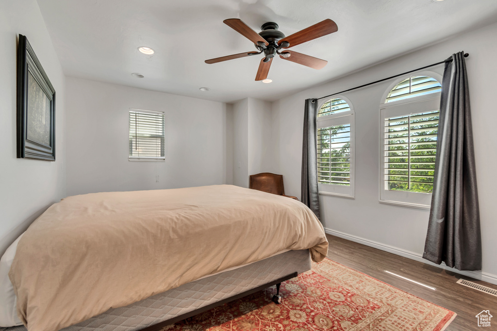 Bedroom featuring multiple windows, wood finished floors, baseboards, and recessed lighting