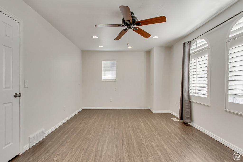 Unfurnished room featuring wood finished floors, a ceiling fan, baseboards, and recessed lighting