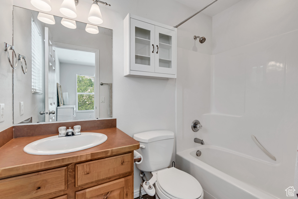Bathroom with toilet, tub / shower combination, and vanity