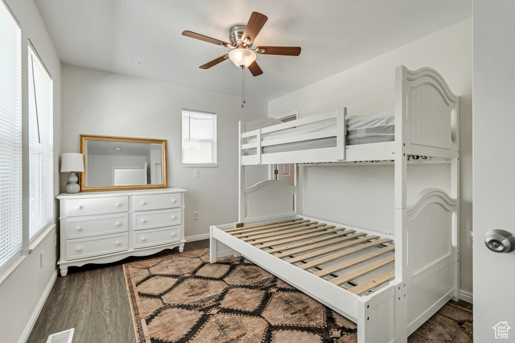 Bedroom with baseboards, dark wood-style flooring, and a ceiling fan