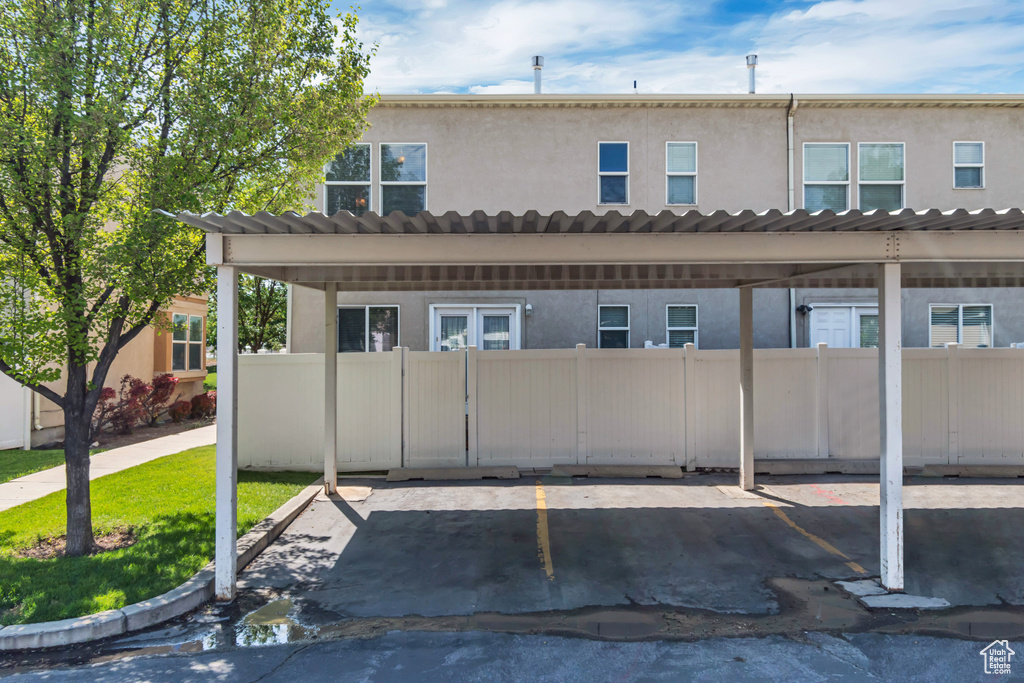 Rear view of house featuring stucco siding and covered parking