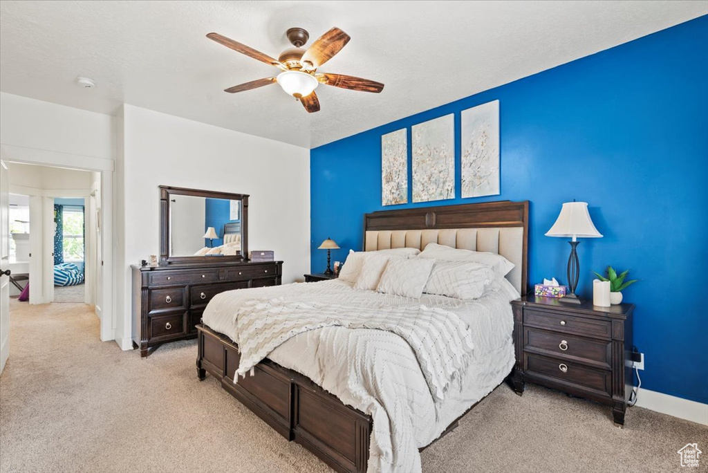 Carpeted bedroom with baseboards and a ceiling fan