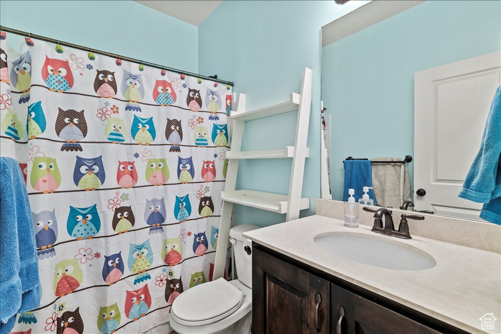 Bathroom with vanity, toilet, and curtained shower