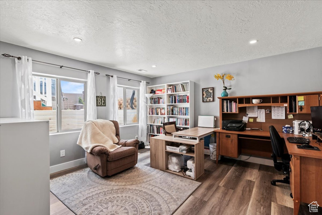 Home office with wood finished floors, a textured ceiling, recessed lighting, and baseboards