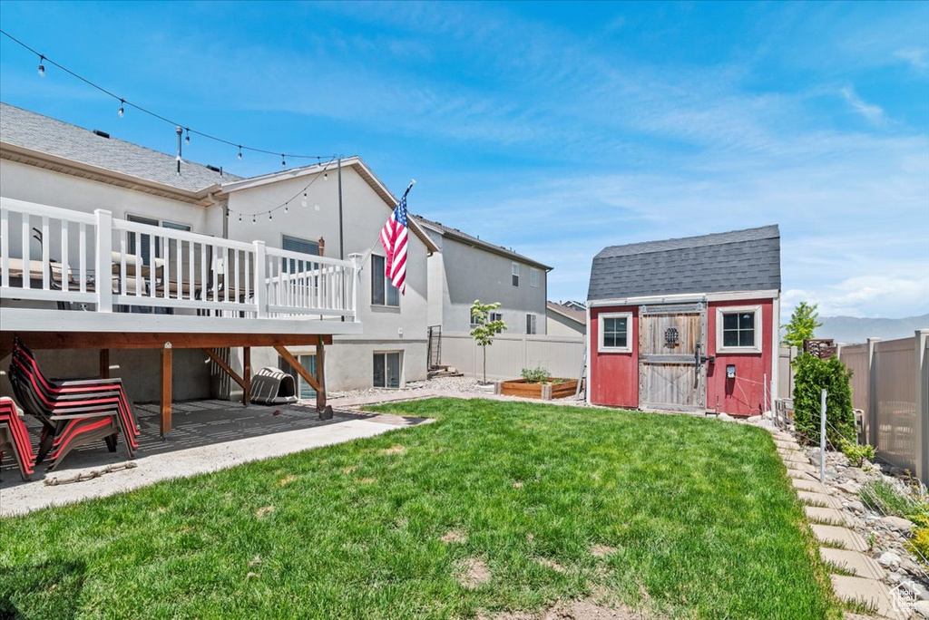 View of yard featuring a patio and a wooden deck
