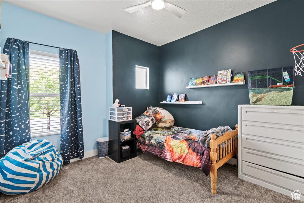 Bedroom with multiple windows, carpet flooring, and a ceiling fan
