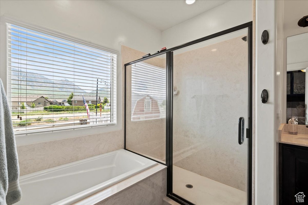 Bathroom with a garden tub, a stall shower, and vanity