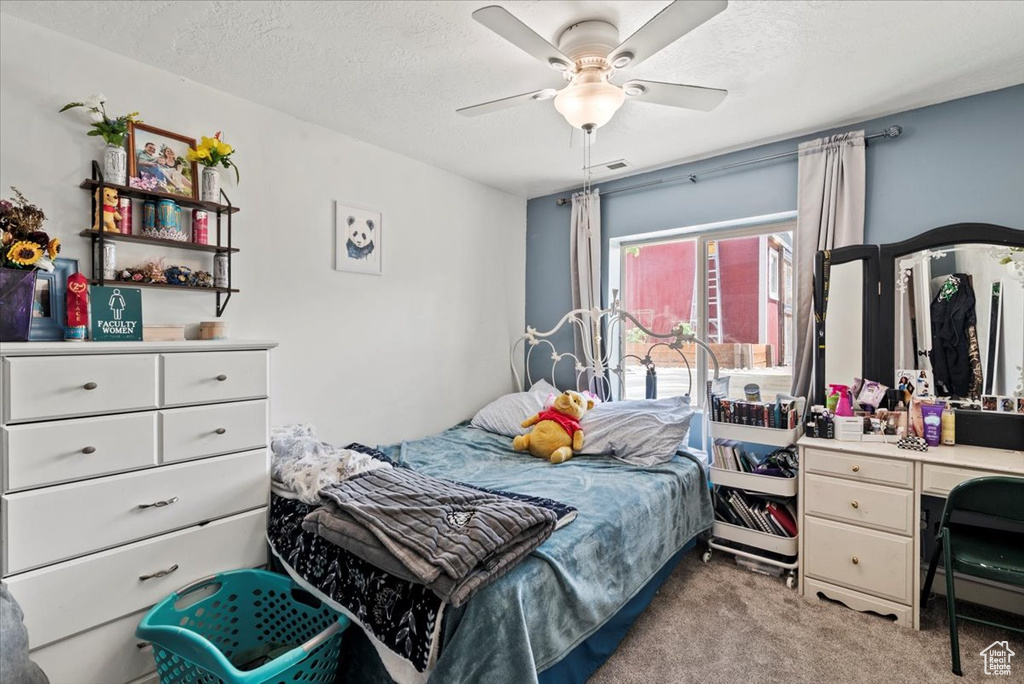 Bedroom with light carpet, a textured ceiling, and ceiling fan