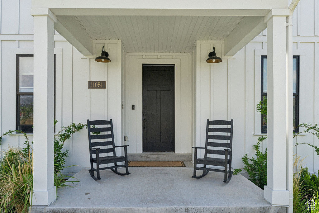 Property entrance with board and batten siding and a porch