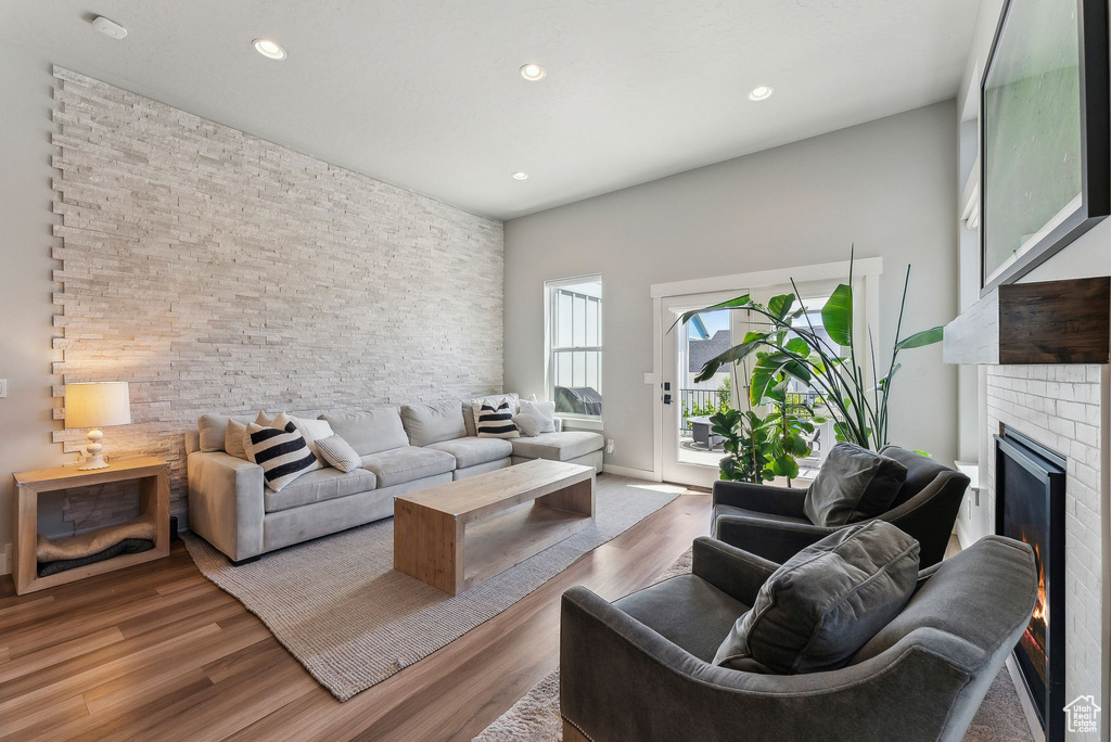 Living room with a glass covered fireplace, light wood-style floors, and recessed lighting