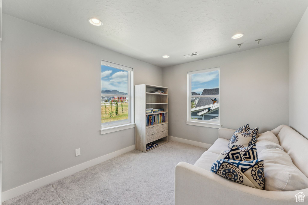 Living area featuring baseboards, carpet floors, and recessed lighting