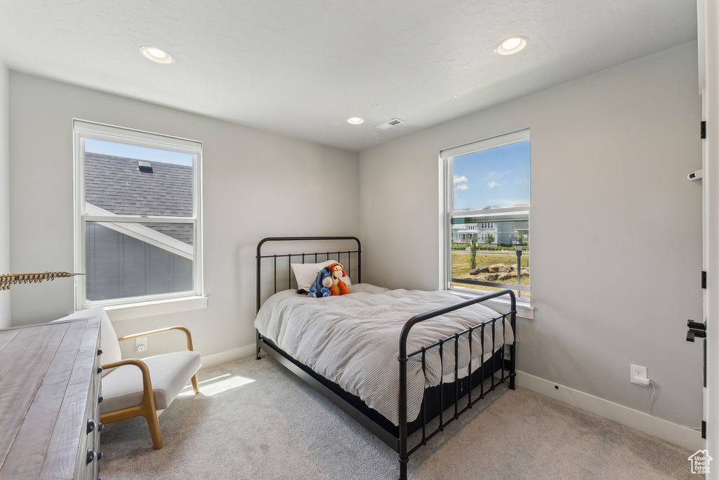 Carpeted bedroom with multiple windows, baseboards, and recessed lighting