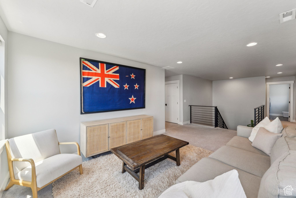 Carpeted living room featuring recessed lighting and baseboards