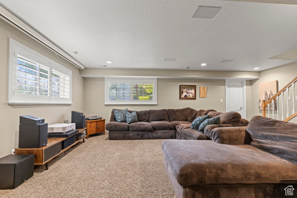 Carpeted living room featuring stairs and recessed lighting