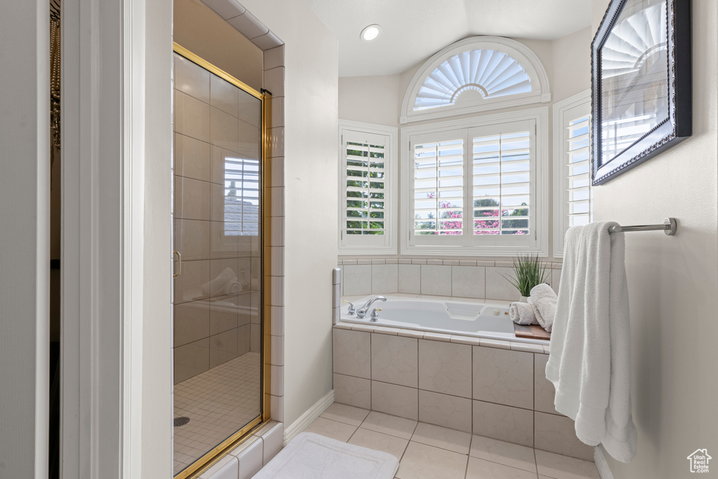 Bathroom with tile patterned flooring, a stall shower, a garden tub, and lofted ceiling