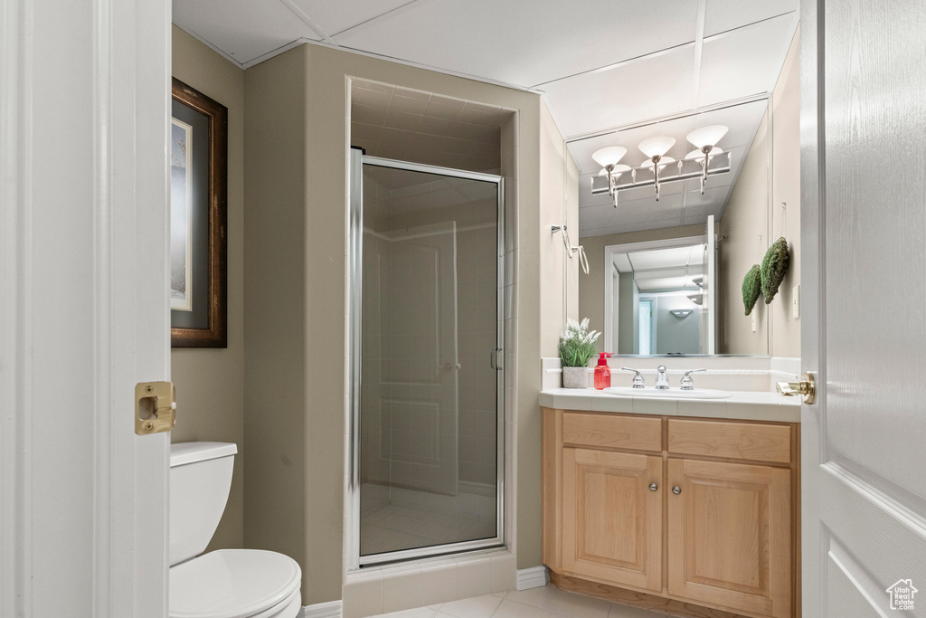 Full bathroom with toilet, vanity, a shower stall, and tile patterned flooring
