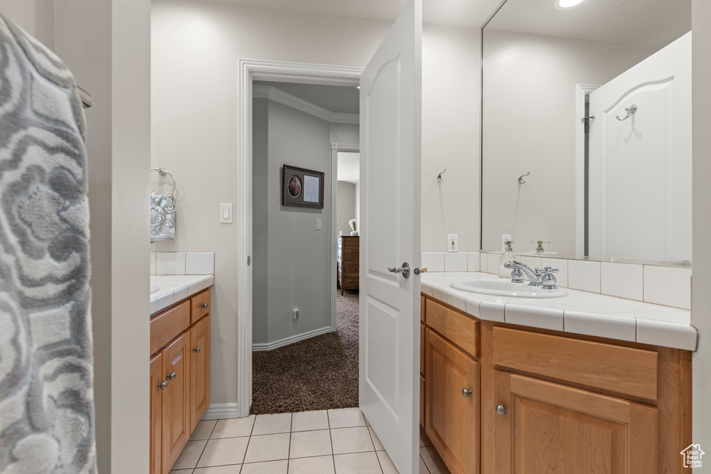 Bathroom with vanity, tile patterned floors, and baseboards