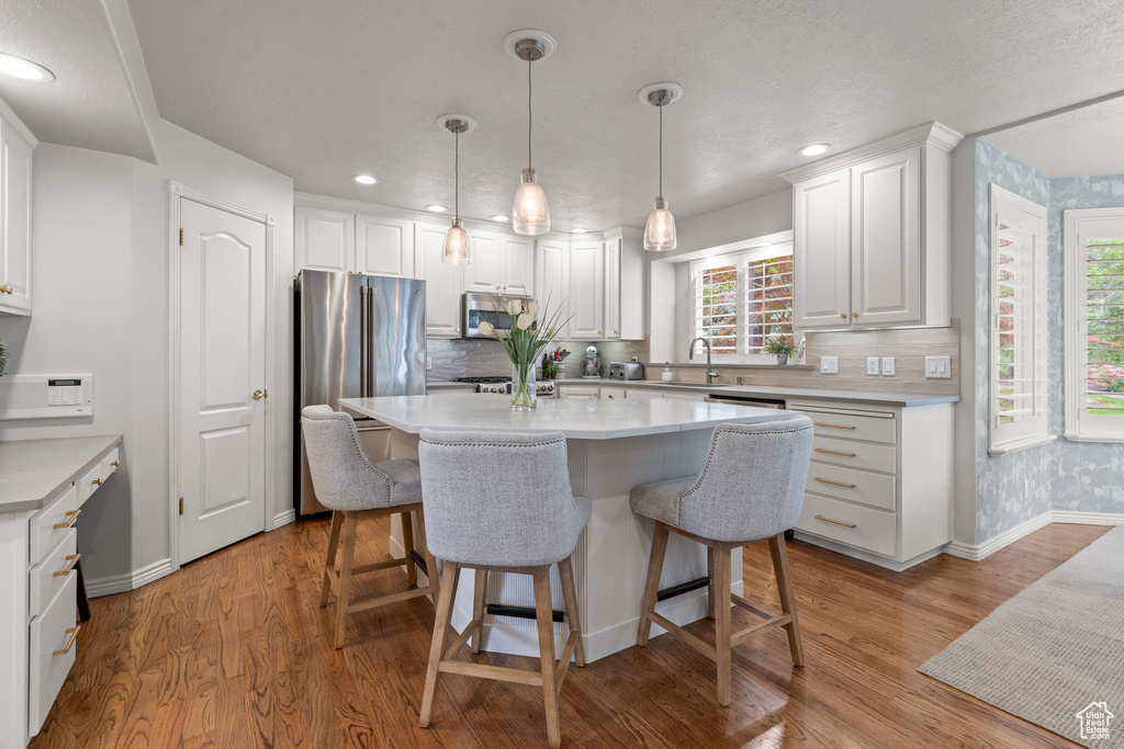 Kitchen featuring stainless steel appliances, baseboards, a sink, plenty of natural light, and recessed lighting