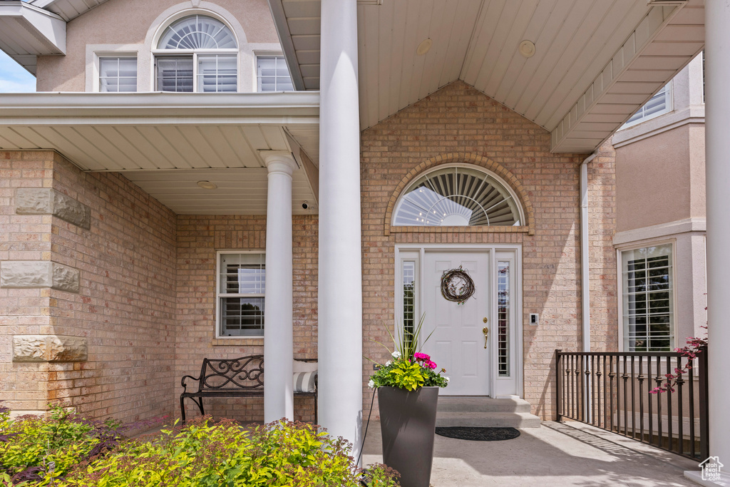 Entrance to property with brick siding and a porch