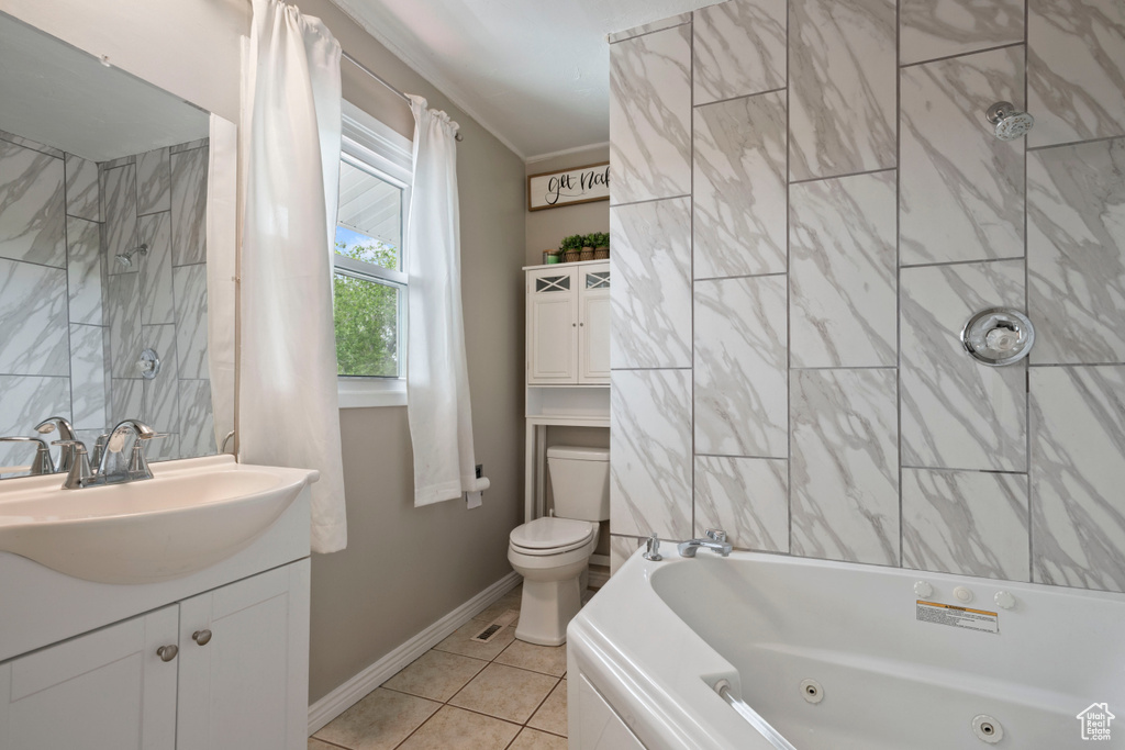Full bath with vanity, toilet, tile patterned floors, baseboards, and a combined bath / shower with jetted tub