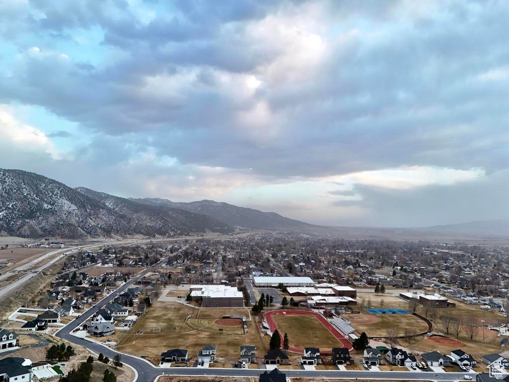 Aerial view of property's location featuring a mountainous background and nearby suburban area
