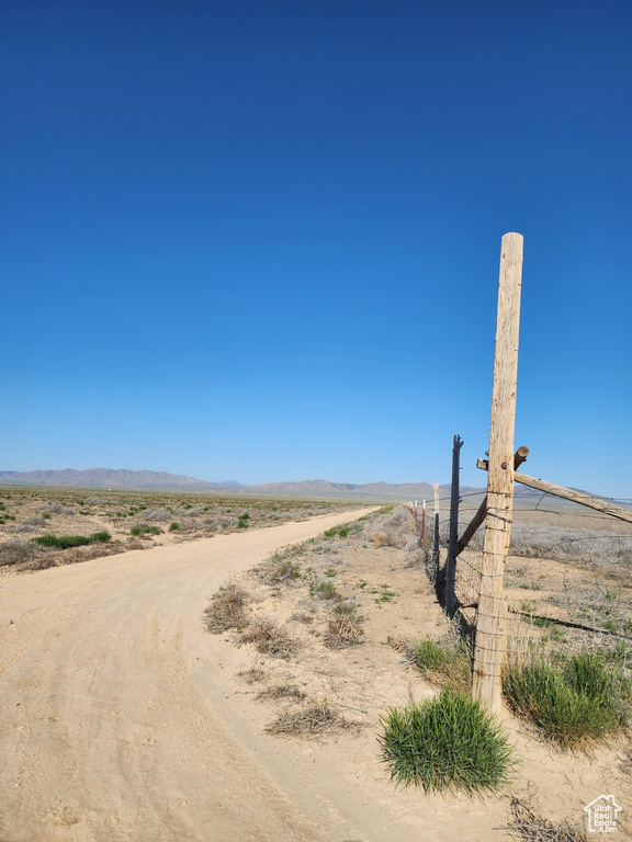View of dirt / gravel road with a rural view and a mountain view
