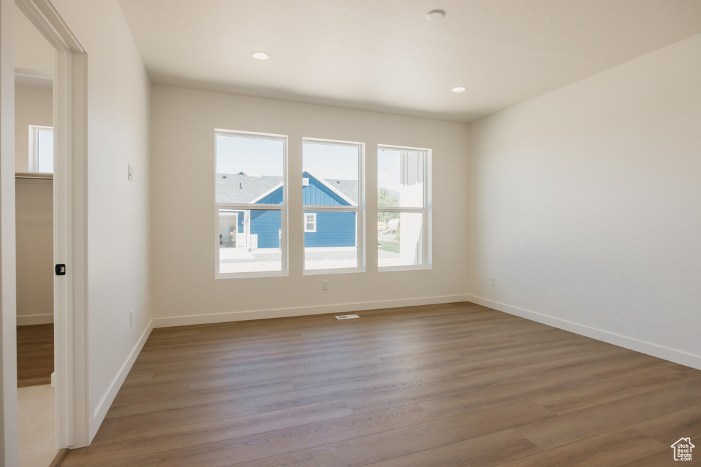 Spare room with light wood-style flooring, baseboards, and recessed lighting