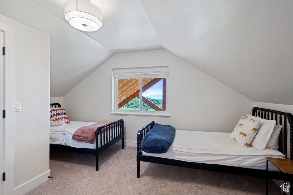 Carpeted bedroom featuring baseboards and lofted ceiling