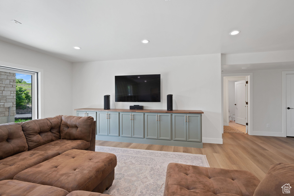 Living room with light wood-type flooring, recessed lighting, and baseboards