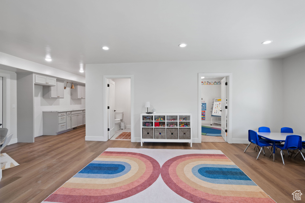 Recreation room with light wood-style flooring, recessed lighting, and baseboards