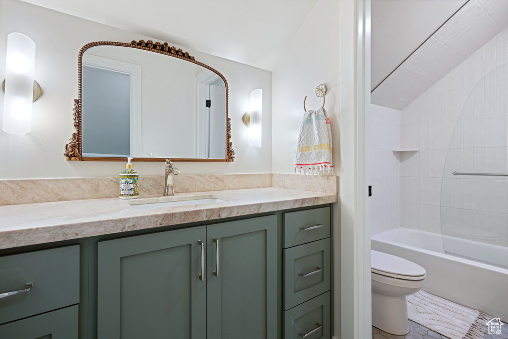 Bathroom with vanity, toilet, bathtub / shower combination, lofted ceiling, and tile patterned floors