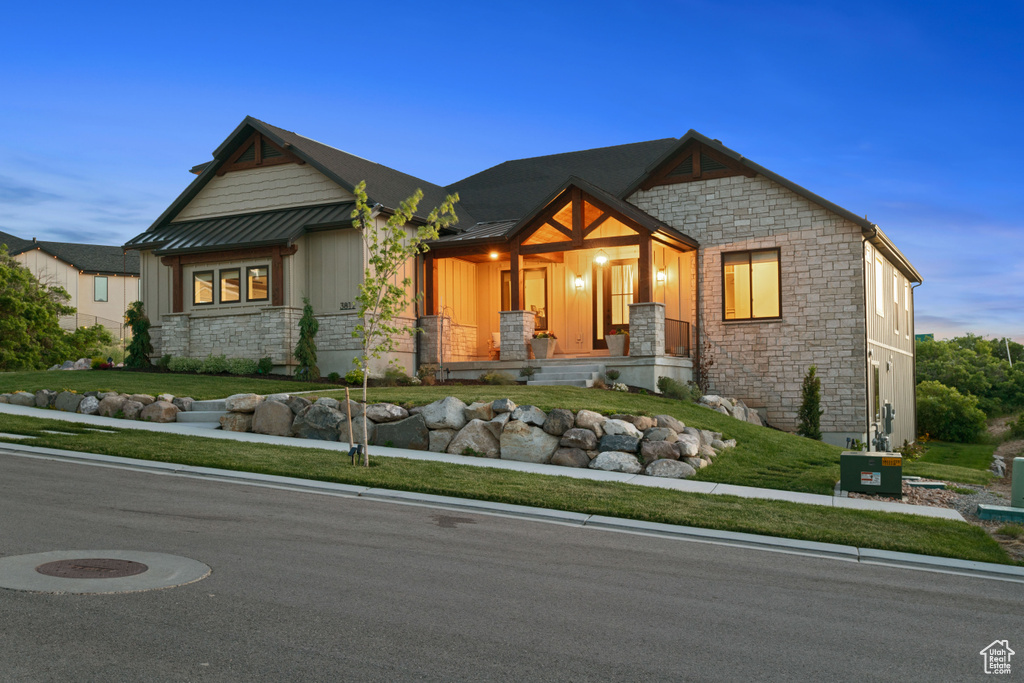 Craftsman-style house with stone siding, covered porch, and board and batten siding