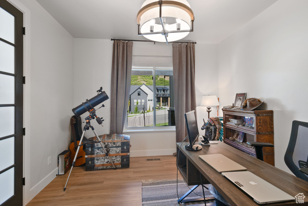 Home office with baseboards, wood finished floors, and a chandelier