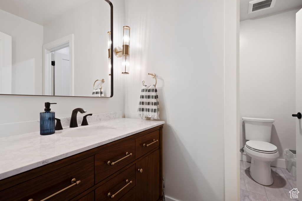 Bathroom with vanity, toilet, and baseboards