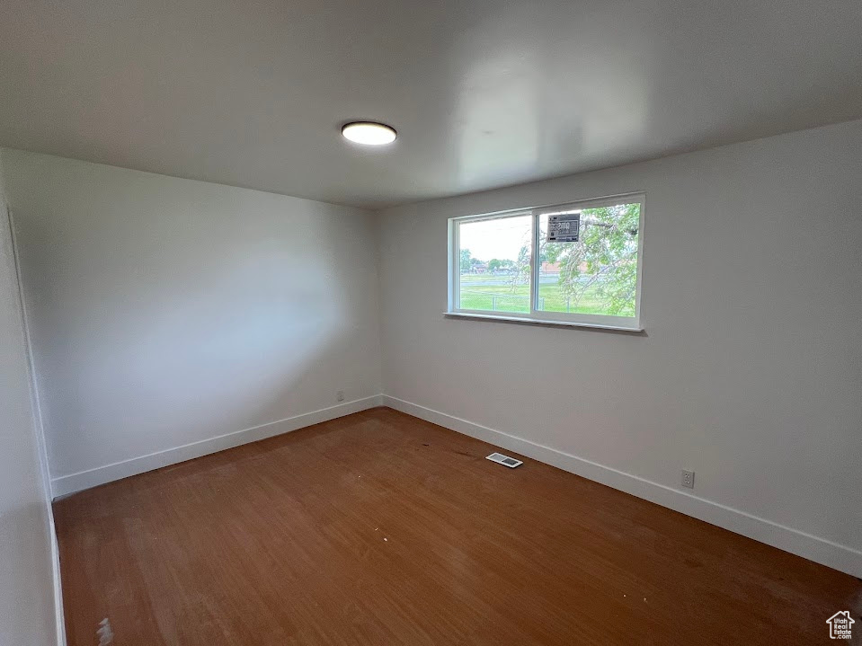 Empty room featuring baseboards and wood finished floors