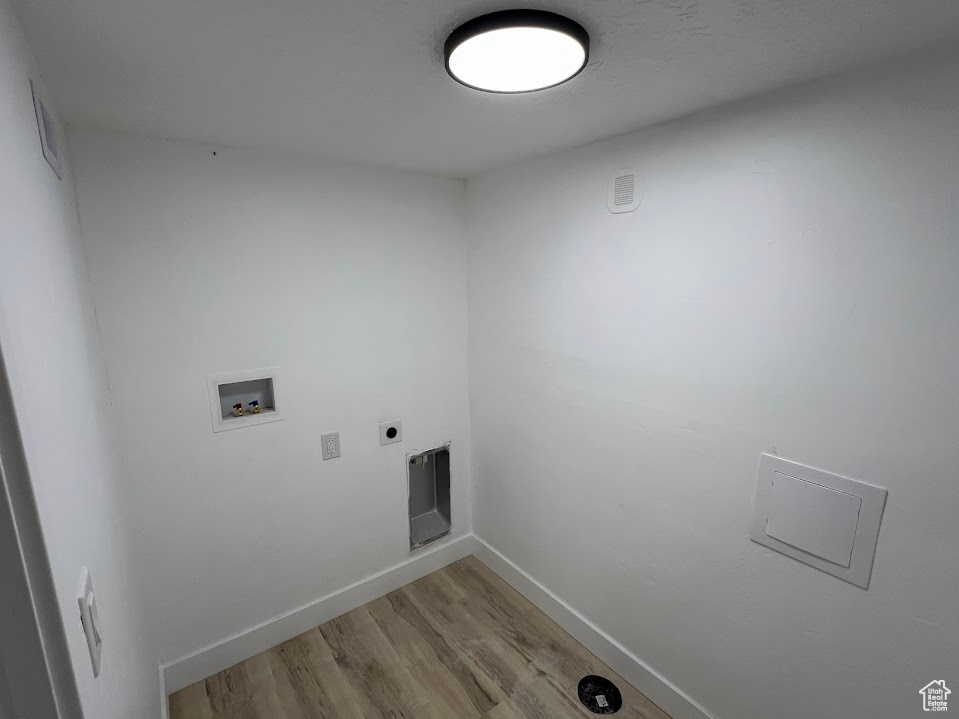 Washroom with light wood-style floors, washer hookup, baseboards, and hookup for an electric dryer