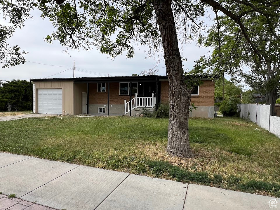 Single story home with a garage, driveway, and brick siding