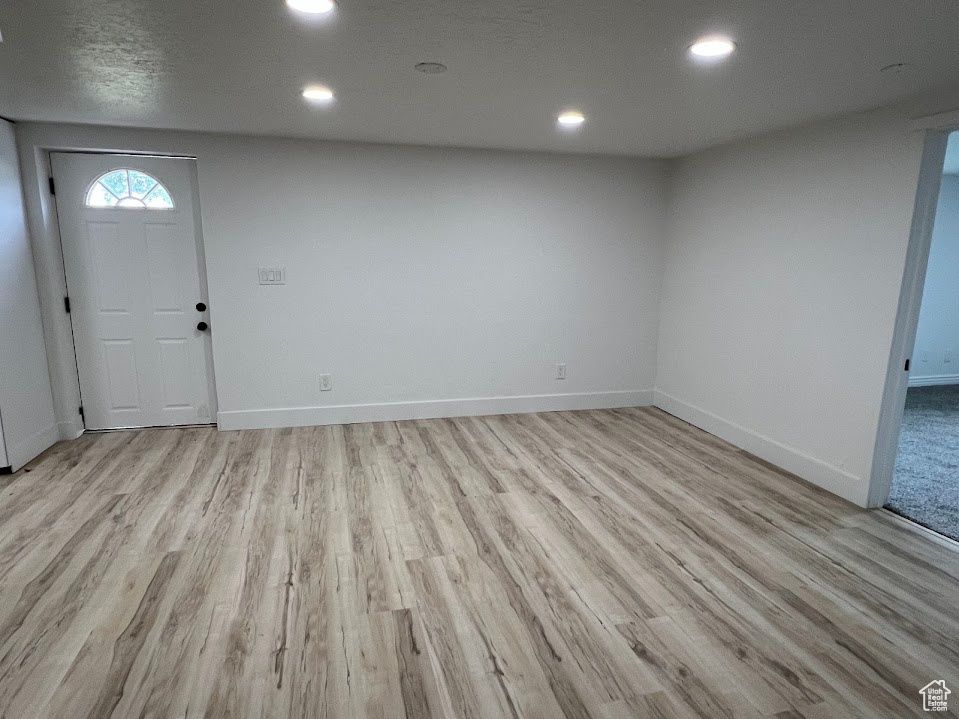 Foyer entrance with light wood-style floors, recessed lighting, and baseboards
