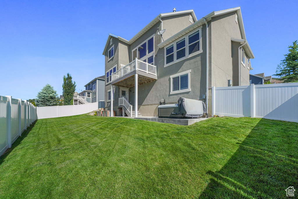 Rear view of property with stucco siding and a balcony